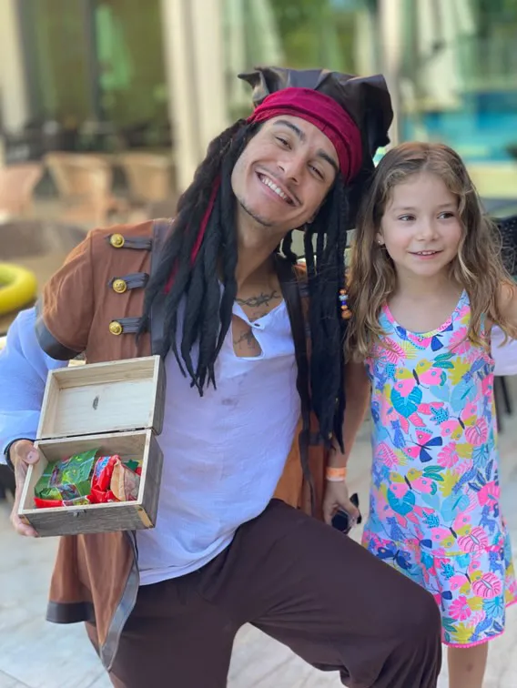 Ted dressed as a pirate with a child beside the treasure chest