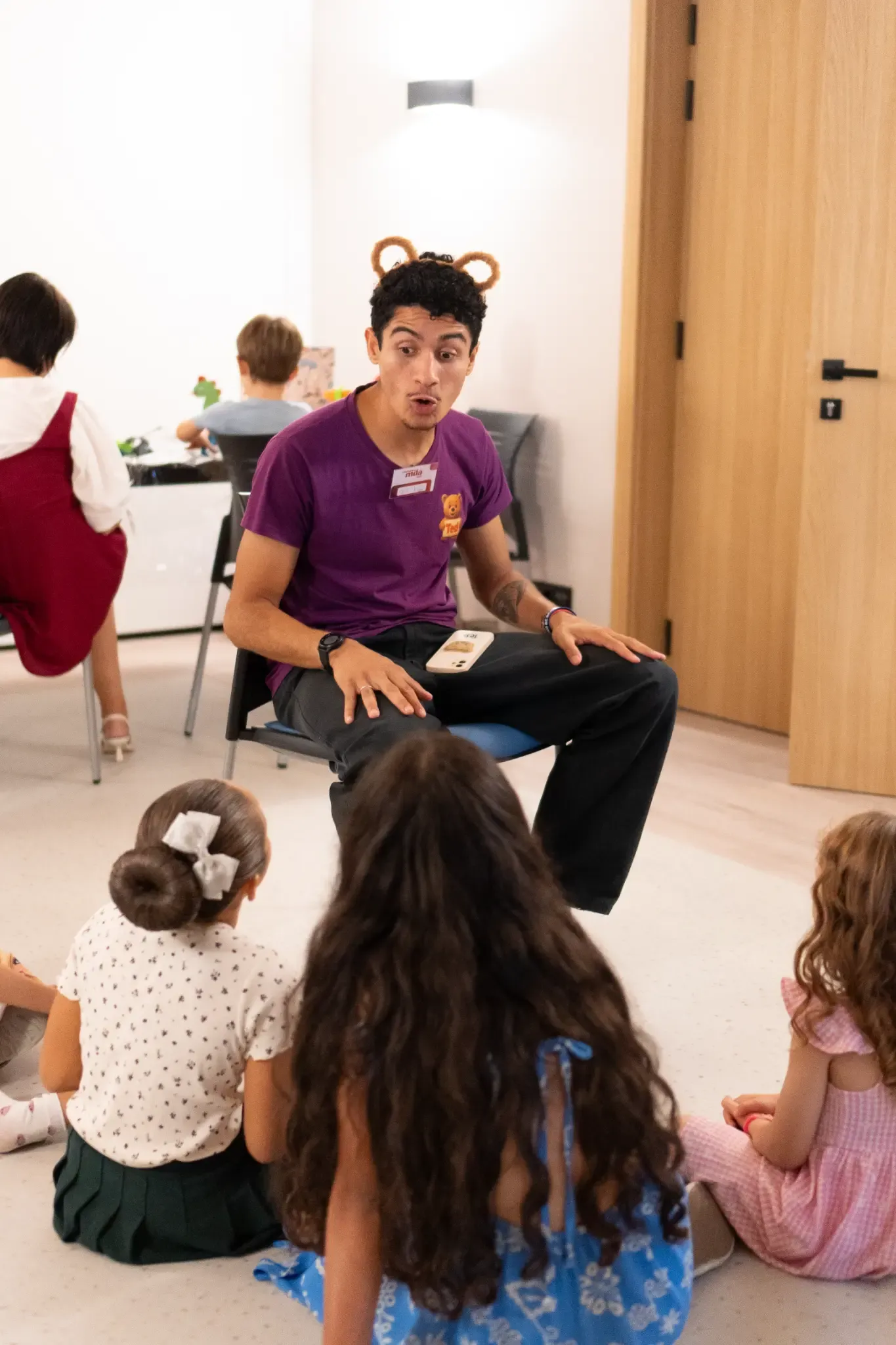 Ted a animar um grupo de crianças sentadas em roda numa festa